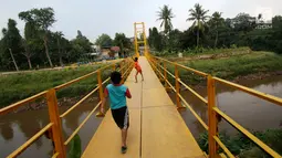 Anak-anak bermain di sekitar jembatan gantung di kawasan Tanjung Barat, Jakarta Selatan, Senin (22/5). Desain konstruksi jembatan tersebut dinilai tidak aman bagi keselamatan. (Liputan6.com/Immanuel Antonius)