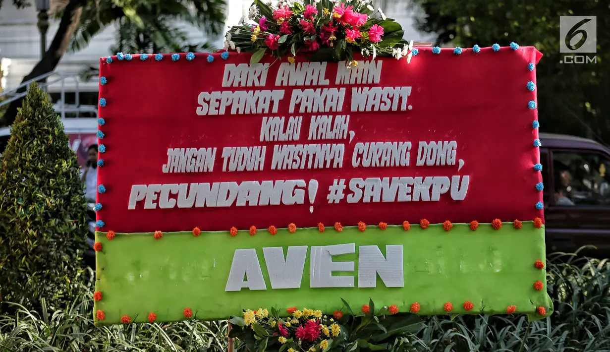 Karangan bunga kembali menghiasi depan Kantor Komisi Pemilihan Umum (KPU) Pusat dan dan ruas Jalan Imam Bonjol,  Menteng, Jakarta Pusat, Senin (6/5/2019). Karangan bunga tersebut dipenuhi kata-kata unik dan lucu berisi ucapan dukungan terhadap KPU RI. (Liputan6.com/Faizal Fanani)