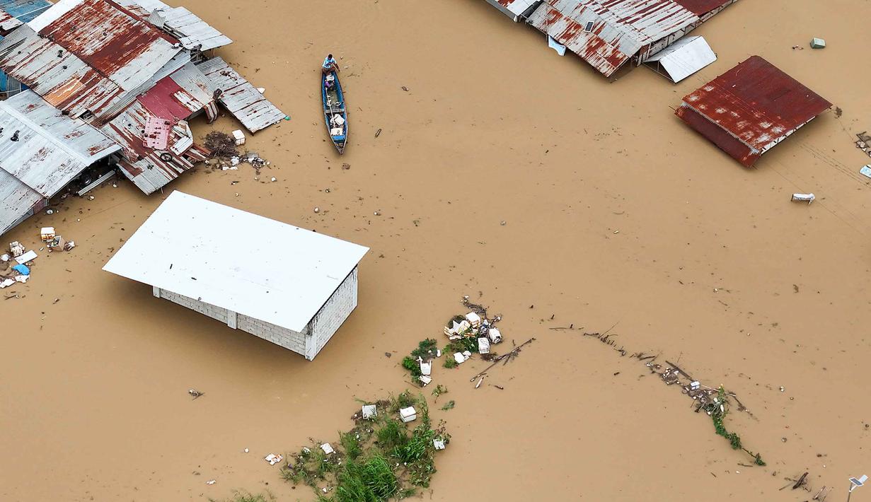 Topan Super Fung-wong merupakan badai tropis ke-21 yang melanda Filipina tahun ini. Tampak foto udara menunjukkan seorang warga mengayuh perahunya di air banjir yang melanda rumah-rumah terendam di Kota Tuguegarao, Provinsi Cagayan, di utara Manila pada 10 November 2025, setelah sungai meluap akibat hujan deras yang disebabkan oleh Topan Super Fung-wong. (John DIMAIN/AFP)