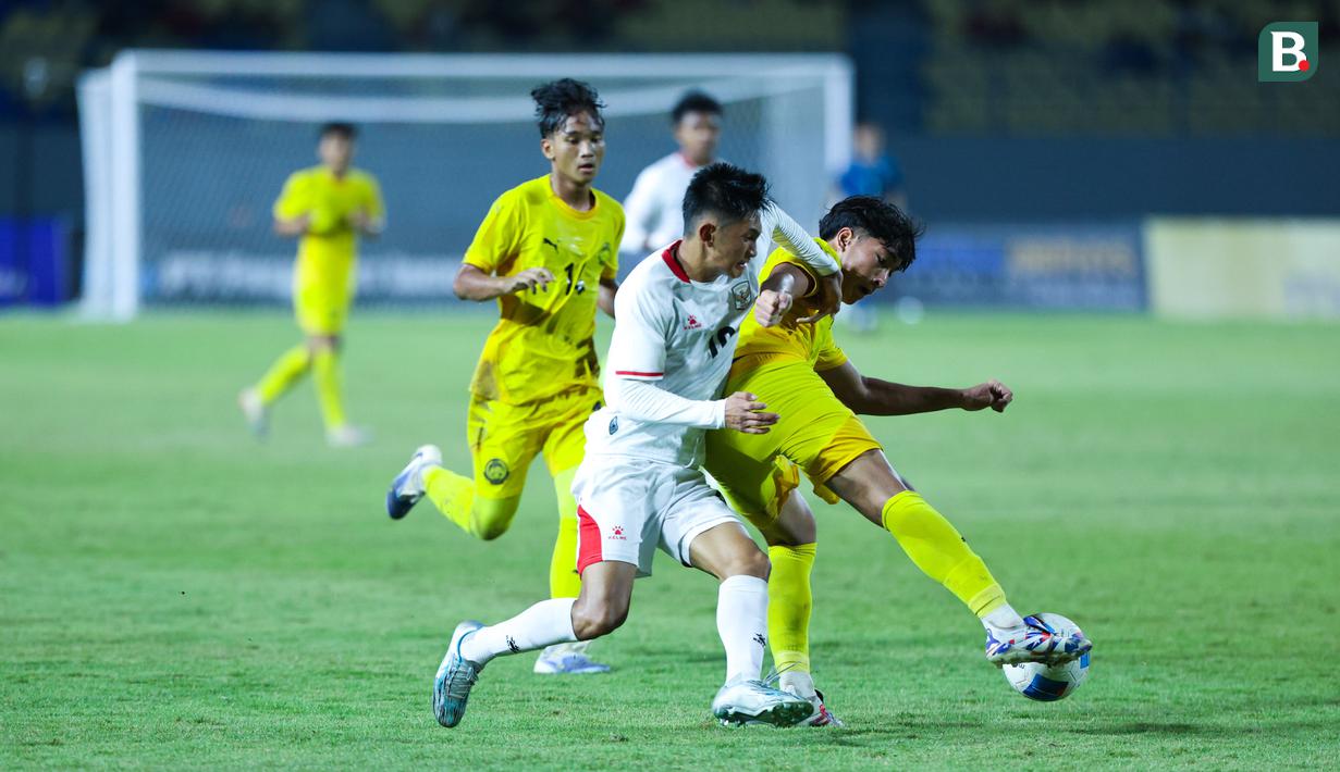 Pemain Timnas Indonesia U-17, Keanu Senjaya, berusaha melewati pemain Malaysia pada laga kedua Grup A Piala AFF U-17 2026 di Stadion Gelora Joko Samudro, Gresik, Jawa Timur, Kamis (16/4/2026) malam. (Bola.com/M Iqbal Ichsan)