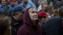 Seorang wanita melihat ke atas saat dia mengantri dengan orang lain untuk menerima jatah roti harian, di sebuah sekolah di Mykolaiv, Ukraina, Selasa (25/10/2022). Pada Distrik Varvarivka yang ditempati ribuan warga ini, satu orang diperbolehkan menerima roti gratis hanya sekali dalam tiga hari. (AP Photo/Emilio Morenatti)