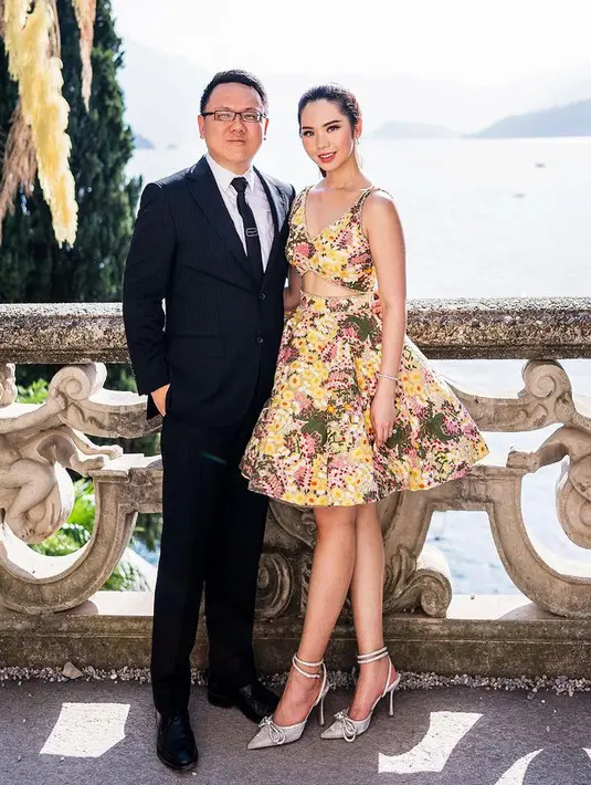 Gwen mengenakan dress cocktail warna kuning dengan gambar floral saat photoshoot di Italia. [@nancywarrencouture]