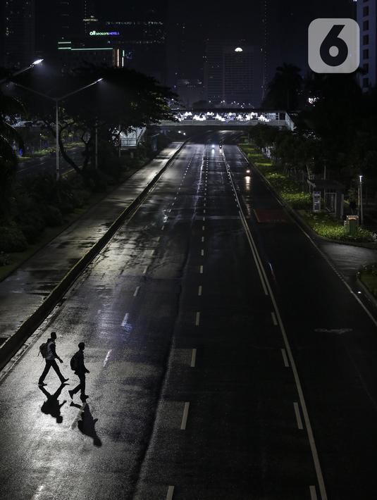 Warga menyeberang saat diberlakukannya Car Free Night dan Crowd Free Night di Jalan Sudirman-MH Thamrin, Jakarta (31/12/2020). Jalan Sudirman-MH Thamrin ditutup pada malam pergantian tahun untuk mencegah kerumunan warga. (Liputan6.com/Johan Tallo)