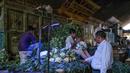 Seorang pria membeli membeli kembang kol di pasar grosir buah dan sayuran di New Delhi, India (27/3). Pasar jalanan Delhi dilaporkan memberikan omset lebih besar dibandingkan dengan mal. (AFP Photo/Noemi Cassanelli)