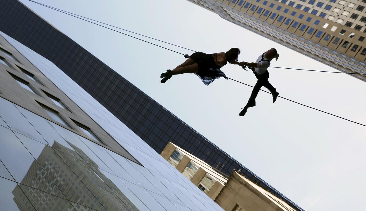 Sepasang penari melakukan aksi tarian diantara gedung, Manhattan borough New York (19/4). Aksi nekat ini merupakan bagian dari pembukaan toko "Hublot"di Fifth Avenue, Manhattan. (REUTERS/Andrew Kelly)