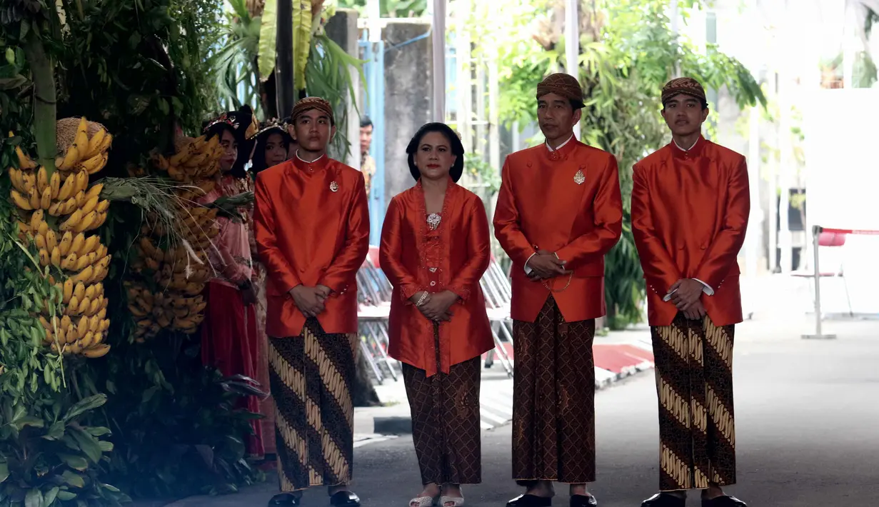 Presiden Joko Widodo (Jokowi) didampingi Ibu Negara, Iriana serta Gibran Rakabuming dan Kaesang Pangarep menunggu tamu yang pulang dari kediamannya di Jalan Kutai Utara, Solo usai prosesi siraman Kahiyang Ayu, Selasa (7/11). (Liputan6.com/Angga Yuniar)
