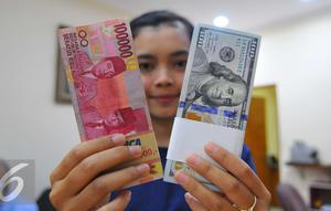 Petugas menunjukkan mata uang dolar dan mata uang rupiah di penukaran uang di Jakarta, Rabu (9/11). Nilai tukar rupiah terhadap dolar Amerika Serikat (AS) pada saat jeda siang ini kian terpuruk di zona merah. (Liputan6.com/Angga Yuniar)