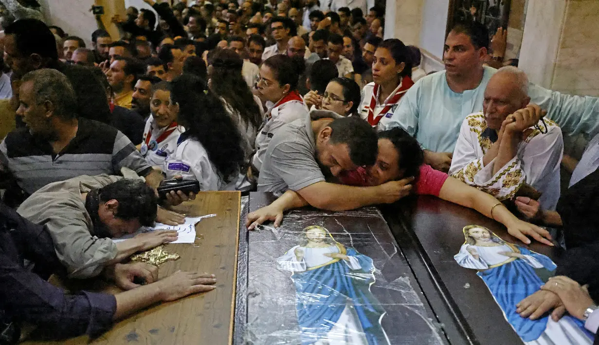 Para pelayat menangis saat pemakaman korban tewas dalam kebakaran gereja kristen koptik di Gereja Santa Perawan Maria, Kairo, Provinsi Giza, Mesir, 14 Agustus 2022. Kobaran api diduga akibat korsleting listrik. (Khaled DESOUKI/AFP)