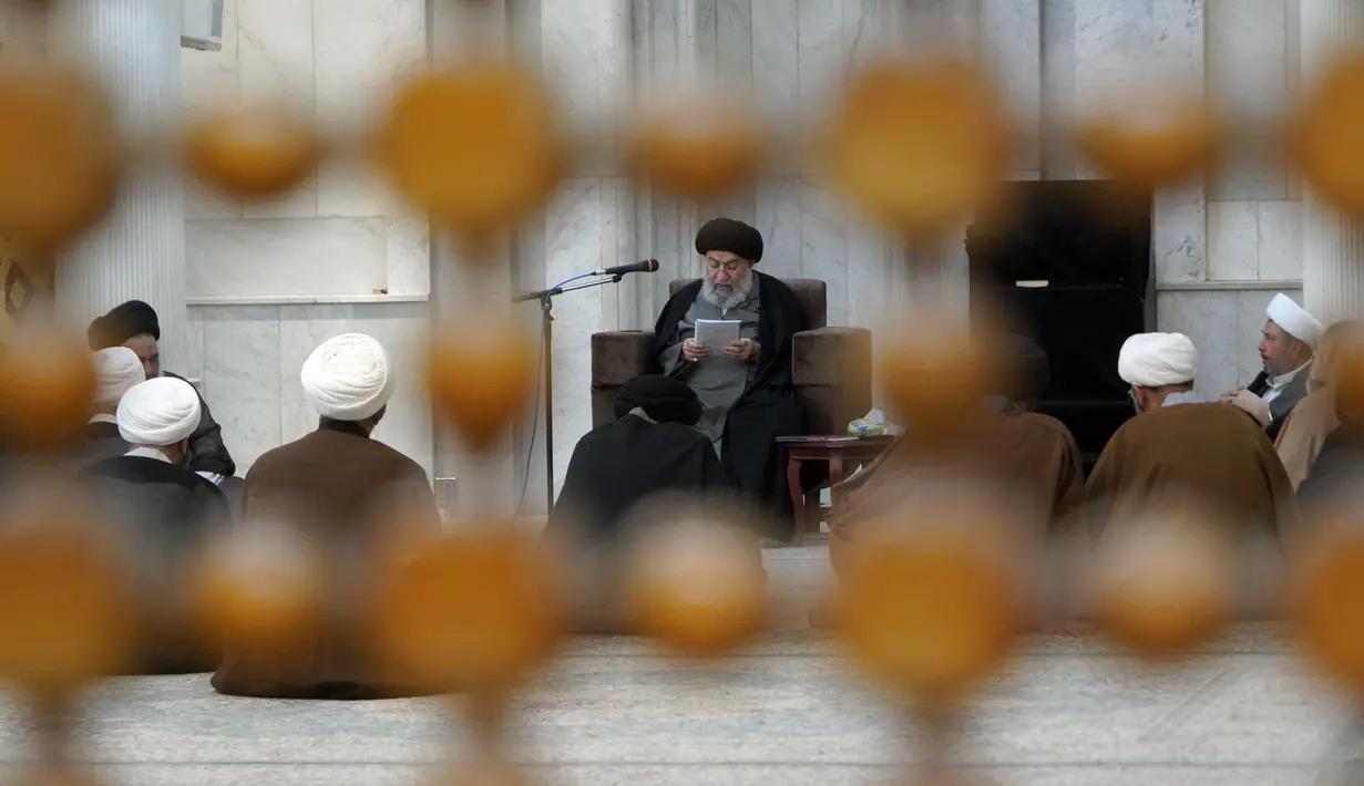 Ulama Syiah Ali Sebzevari, putra mendiang Ayatollah Agung Abd al-Aala Sebzevari, membacakan untuk murid-muridnya selama kelas di kota suci Najaf, Irak, 23 November 2021. Sekolah-sekolah agama di Irak kembali dibuka setelah lebih dari dua tahun di tengah pandemi COVID-19. (Qassem al-KAABI/AFP)