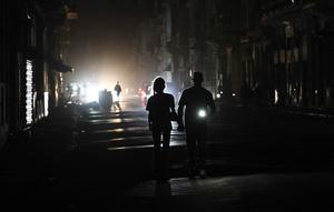 Sebelumnya, pada Senin 16 Maret 2026, Cuba’s Electric Union (UNE) melaporkan bahwa sistem listrik di negara tersebut mengalami keruntuhan total. Tampak dalam foto, orang-orang berjalan di jalanan tanpa aliran listrik selama pemadaman listrik nasional di Havana, Kuba pada Sabtu 21 Maret 2026. (Yamil LAGE/AFP)
