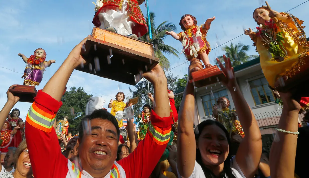 Umat Katolik Roma mengangkat patung simbol Bayi Yesus saat pemberkatan di Manila, Filipina (21/1). Prosesi keagaman tersebut merupakan bagian dari perayaan Santo Nino. (AP Photo / Bullit Marquez)