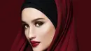 Potret santun Cinta Laura kenakan hijab berwarna merah bata. Penampilannya semakin luar biasa dengan inner hitam, yang kemudian ditumpuk dengan kain panjang berwarna merah. [Foto: Instagram/claurakiehl]