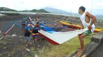 Warga dan nelayan membawa perahu kayu ke tempat yang lebih aman di sebuah desa di Kota Legaspi, provinsi Albay, selatan Manila, Filipina pada 16 November 2024. (CHARISM SAYAT/AFP)