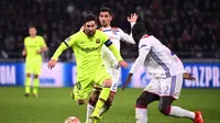 Aksi Lionel Messi mencoba melewat dua pemain Lyon pada leg 1, babak 16 besar Liga Champions yang berlangsung di stadion Parc Olympique Lyonnais, Lyon, Rabu (20/2). Barcelona bermain imbang 0-0 kontra Lyon. (AFP/Franck Fife)