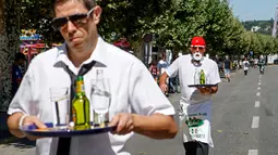 Pramusaji beradu kecepatan sambil membawa nampan dalam Waiters Race ke-21 di Fetes de Geneve, Swiss, 6 Agustus 2017. Lomba yang tak biasa ini diikuti oleh 80 peserta yang merupakan pelayan restoran dan kafe. (Salvatore Di Nolfi/Keystone via AP)