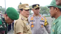 Bupati Sukiman dengan Kapolres Rokan Hulu AKBP Budi Setiyono mengecek pasukan Linmas yang dikerahkan mengawal hari pencoblosan di tempat pemungutan suara. (Liputan6.com/M Syukur)