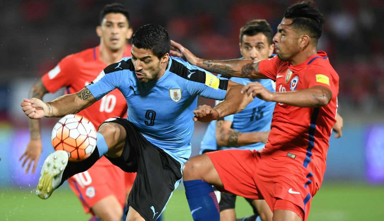 Striker Uruguay asal klub Barcelona, Luis Suarez, dijaga ketat pemain Cile pada laga Kualifikasi Piala Dunia 2018 zona CONMEBOL di Stadion Nasional Julio Martinez Pradanos, Santiago, Rabu (16/11/2016) pagi WIB. (AFP/Martin Bernetti)
