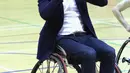 Pangeran William dengan kursi roda mencoba memasukkan bola basket ke ring saat kunjungannya ke Copperbox Arena, London, Kamis (22/3). Pangeran William menemui pemain basket berkursi roda yang diharapkan dapat bermain di Commonwealth Games 2022. (AP Photo)