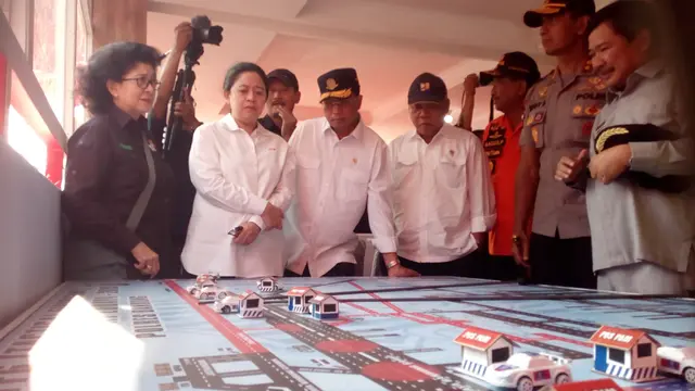 Dibantu oleh Kapolda Jabar Irjen Pol. Rudy Sufahriadi, Menteri PMK Puan Maharani, nampak tengah mengamati rute mudik nasional Jabar selatan di pos terpadu, Nagreg, Kabupaten Bandung Jawa Barat