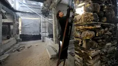 Seniman asal Belanda, Marjan Teeuwen terlihat memanjat tangga saat menciptakan sebuah karya arsitektur dari reruntuhan rumah yang hancur bekas perang pada 2014 di Khan Younis, selatan Jalur Gaza, 12 November 2016. (REUTERS/Ibraheem Abu Mustafa)