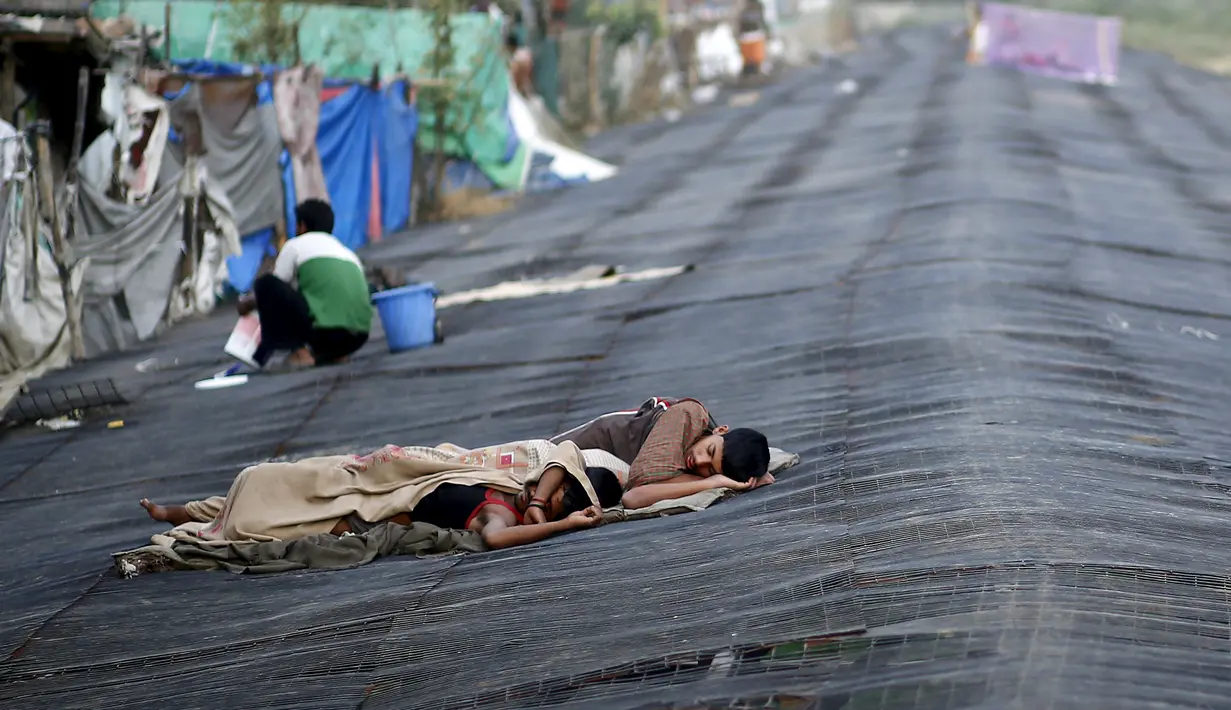 Sejumlah orang tidur di atas bangunan sementara saat gelombang panas menerjang di New Delhi, India, (28/5/2015). Gelombang panas di India telah menewaskan sedikitnya 1.371 karena suhu meningkat di atas 47 Celcius. (REUTERS/Anindito Mukherjee)