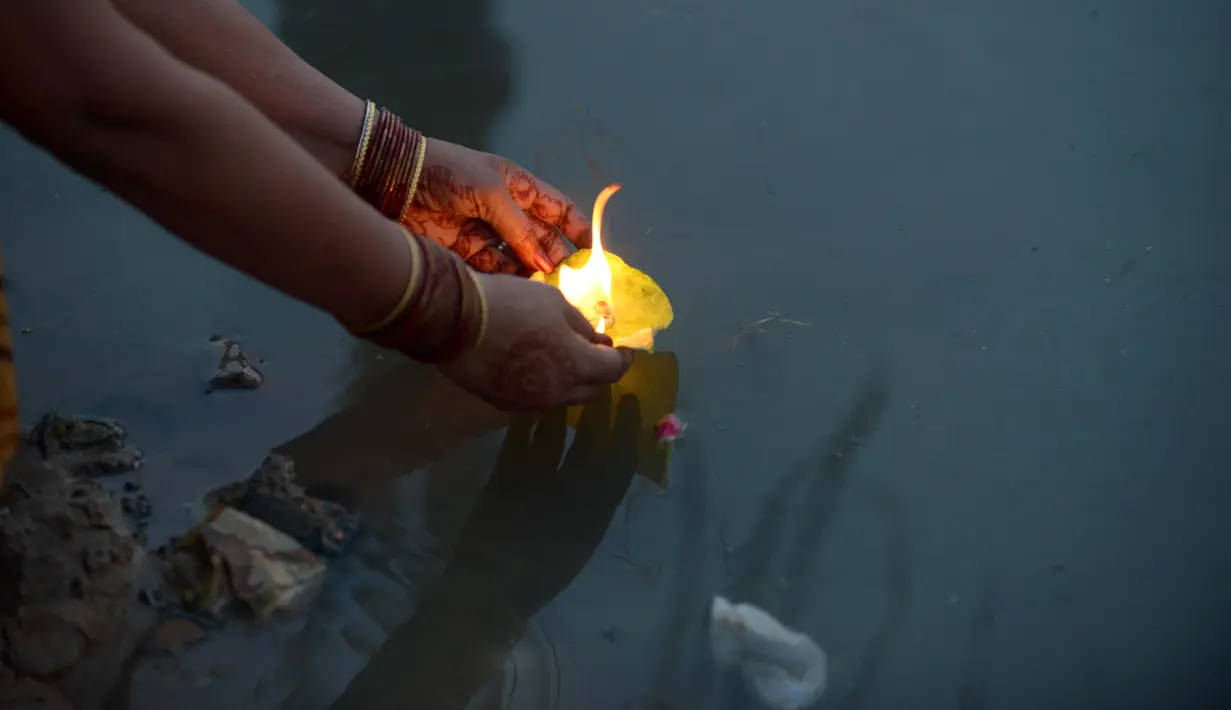 Umat Hindu India memanjatkan doa pada matahari saat festival Chhath di tepi Danau Hussain Sagar di Hyderabad, Selasa (17/11). Dalam festival tersebut, sejumlah umat Hindu berdoa saat matahari terbit dan tenggelam. (AFP PHOTO/ Sam PANTHAKY)