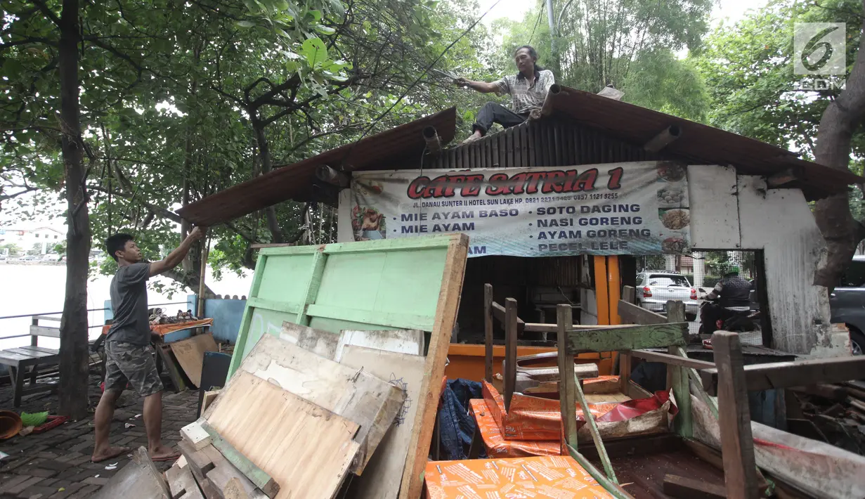 Pedagang membongkar atap lapaknya di kawasan Danau Sunter, Jakarta Utara, Jumat (19/1). Penataan dilakukan agar kawasan Danau Sunter tidak terlihat kumuh dan menjadi sedap dipandang mata. (Liputan6.com/Arya Manggala)