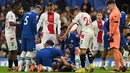 Para pemain Chelsea dan Southampton menghampiri bek Chelsea, Cesar Azpilicueta yang mengalami cedera akibat tendangan salto penyerang Southampton, Sekou Mara yang mengenai kepala selama pertandingan Liga Inggris di Stamford Bridge di London (18/2/2023). (AFP/Glyn Kirk)