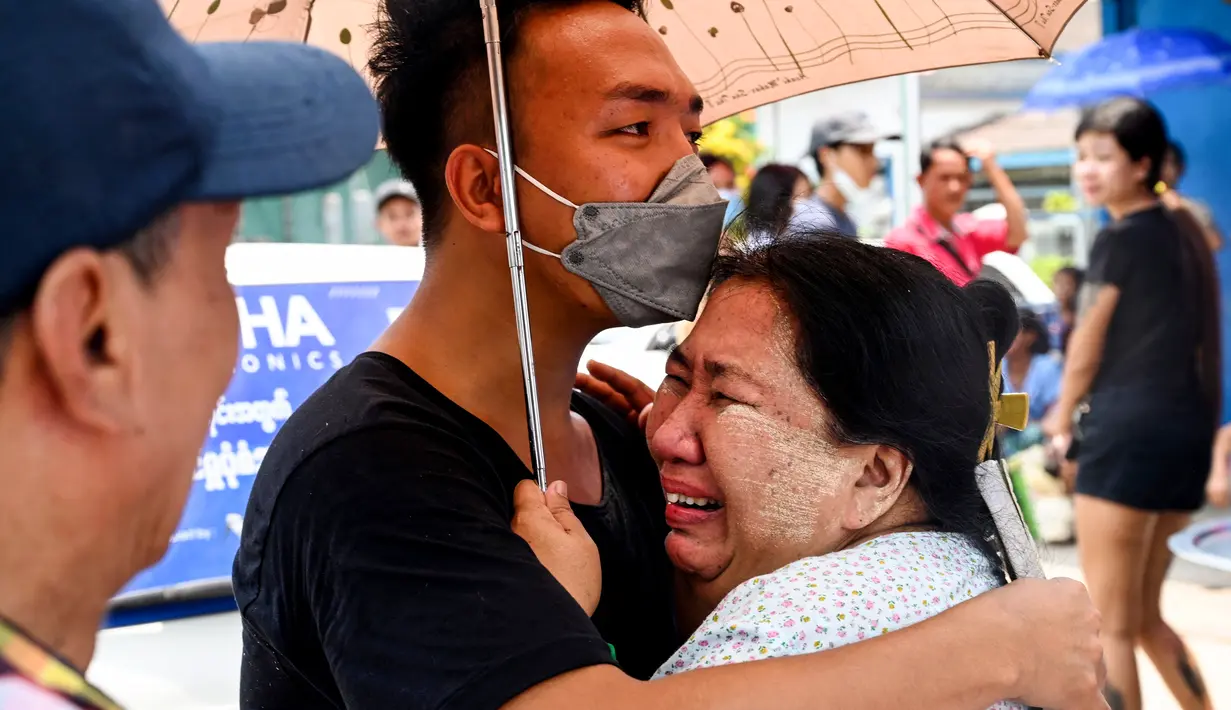 Seorang pria merayakan dengan seorang kerabatnya setelah dibebaskan dari Penjara Insein di Yangon pada 17 April 2023. (AFP/STR)