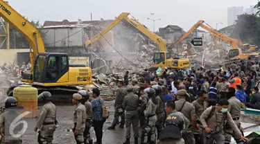 Sejumlah Petugas gabungan saat berjaga di kawasan prostitusi Kalijodo, Jakarta Utara, Senin (29/2). Dalam hitungan jam, puluhan bangunan di kawasan tersebut mulai rata dengan tanah serta menjadi tontonan warga. (Liputan6.com/Immanuel Antonius)