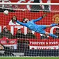 Penjaga gawang Manchester United, David De Gea (tengah), berhasil menghalau bola dari sundulan pemain Fulham dalam babak perempat final Piala FA 2022/2023, Minggu (19/3/2023) malam WIB. Berkat hasil ini, Manchester United pun berhak melenggang ke babak semifinal untuk menghadapi Brighton di Wembley. (AFP/Paul Ellis)