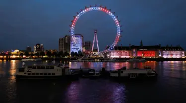 Eye menyalakan lampu berwarna merah, biru dan putih untuk menghormati kelahiran bayi laki-laki  Pangeran Harry dan Meghan Markle di London, Senin (6/5/2019). Bayi yang hingga kini belum diberi nama tersebut, lahir pada pukul 5:26 pagi waktu setempat dengan berat 3,2 kg. (Tolga AKMEN/AFP)