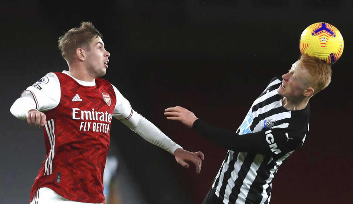 Pemain Arsenal, Emile Smith Rowe, berebut bola dengan pemain Newcastle United, Matthew Longstaff, pada laga Liga Inggris di Stadion Emirates, Senin (18/1/2021). Arsenal menang dengan skor 3-0. (Adam Davy/Pool via AP)