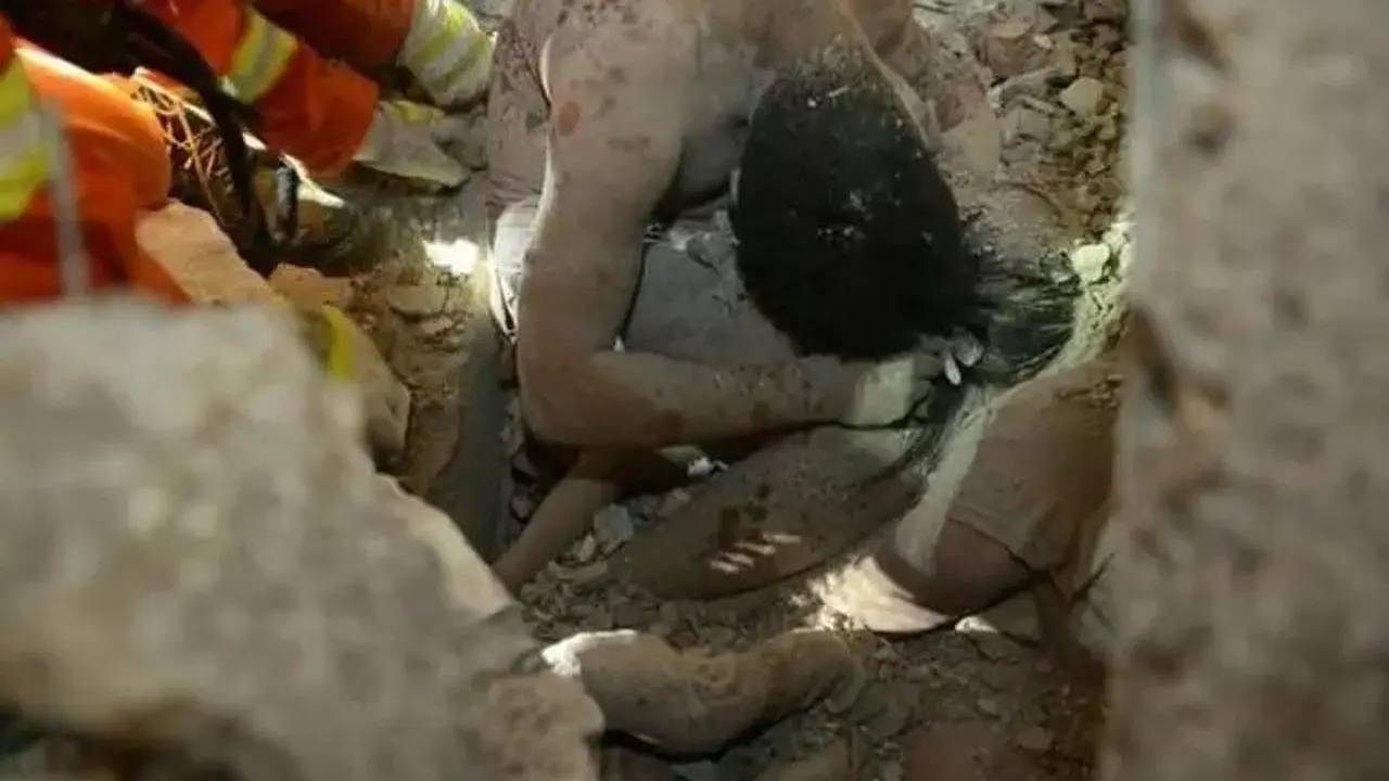Kedua orangtua yang terkubur puing saat melindungi putrinya. (en.people.china)