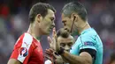 Wasit Damir Skomina memperingatkan pemain Swiss, Stephan Lichtsteiner, pada laga terakhir Grup A Piala Eropa 2016 di Stade Pierre Mauroy, Lille, Senin (20/6/2016) dini hari WIB. (AFP/Kenzo Tribouillard)