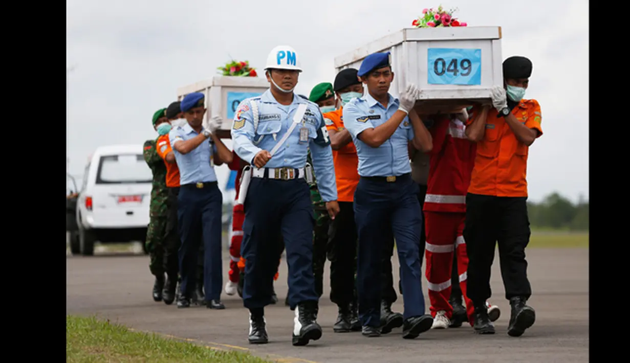 Tim SAR gabungan membawa dua peti mati jenazah penumpang pesawat AirAsia QZ8501 yang jatuh pada tanggal 28 Desember 2014  di pangkalan udara Iskandar, Pangkalan Bun, Kalteng, (19/1/2015). (REUTERS / Beawiharta)