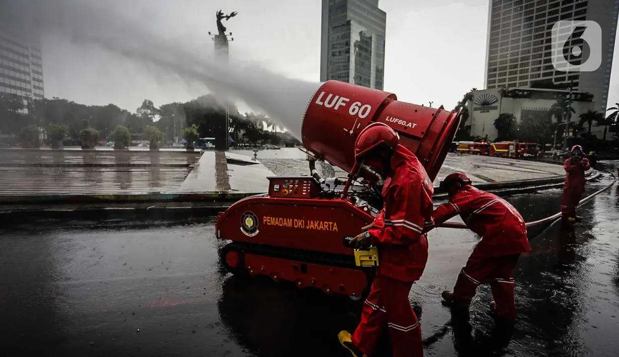 Petugas pemadam kebakaran menyemprotkan cairan disinfektan menggunakan robot LUF 60 di kawasan Bundaran HI, Jakarta, Minggu (22/3/2020). Penyemprotan untuk mencegah penyebaran virus corona COVID-19 ini dilakukan di lima wilayah Ibu Kota. (Liputan6.com/Faizal Fanani)
