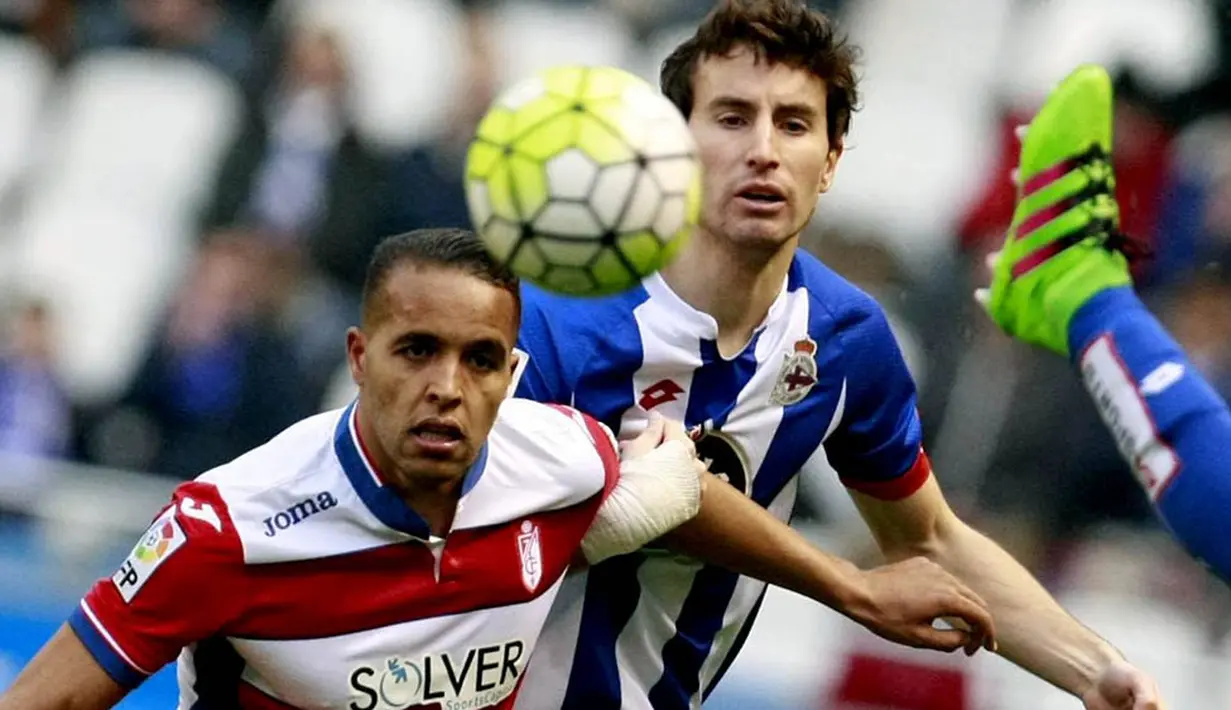 1. Striker Granada, Youssef El-Arabi, berebut bola dengan gelandang Deportivo, Pedro Mosquera, pada laga La Liga Spanyol di Stadion Riazor, Minggu (28/2/2016). Deportivo takluk 0-1 dari Granada. (EPA/Cabalar)