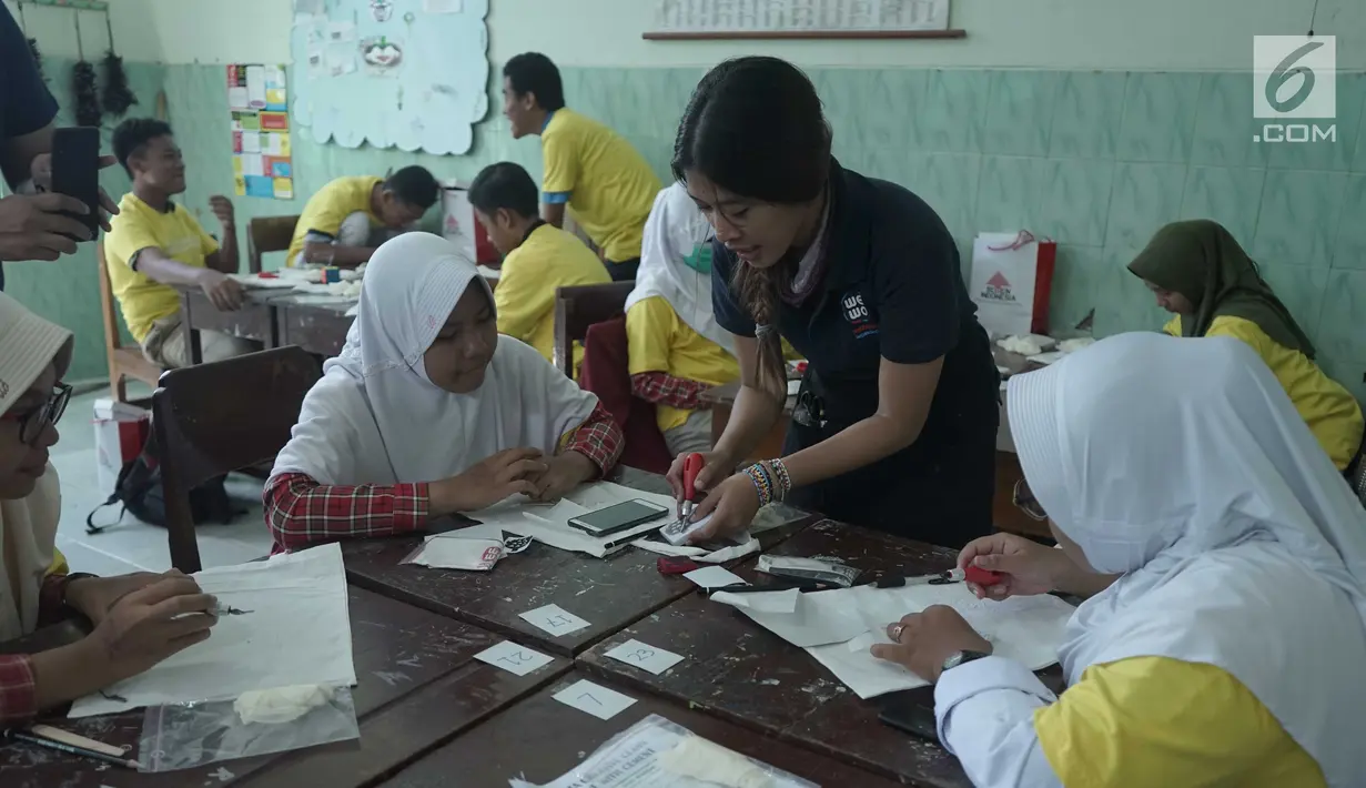 Peserta kelas kreatif mempraktekkan pembuatan Tote Bag Stamping pada acara Semen Indonesia: #MembangunKemandirian di SMAN 1 Magetan, Jawa Timur (2/5/2019). (Liputan6.com/HO/Eko)