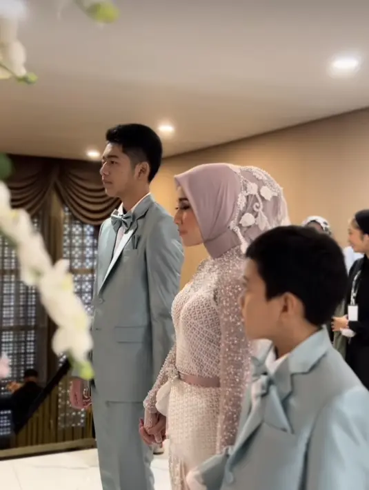 Warna hijab juga disamakan dengan palet dress. Dengan menambahkan veil dengan aksen bunga. (Foto: Instagram @rya_baraba)