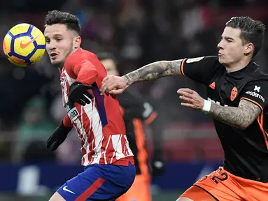 Gelandang Atletico Madrid Saul Niguez berebut bola dengan striker Valencia Santi Mina saat pertandingan Liga Spanyol di stadion Wanda Metropolitano, Madrid (4/2). Atletico Madrid berhasil menang 1-0 atas Valencia. (AFP Photo/Gabriel Bouys)