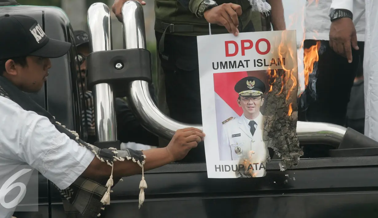 Massa dari ormas Islam se- DIY membakar foto Gubernur DKI Jakarta saat tabligh akbar di Titik Nol km, Yogya, Minggu (9/10). Mereka mendukung PP Muhammadiah yang telah melaporkan Ahok ke Polda Metro Jaya atas penistaan agama. (Liputan6.com/ Boy Harjanto)