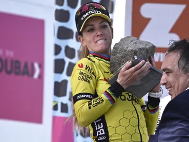 Ekspresi pembalap Team Visma-Lease, Pauline Ferrand-Prevot saat menjunjung trofi kemenangan Paris Roubaix Femmes 2025 pada Sabtu (12/04/2025) waktu setempat. Perlombaan tersebut menempuh 148,5 km dari Denain hingga Roubaix, Prancis. (AFP/Julien De Rosa)