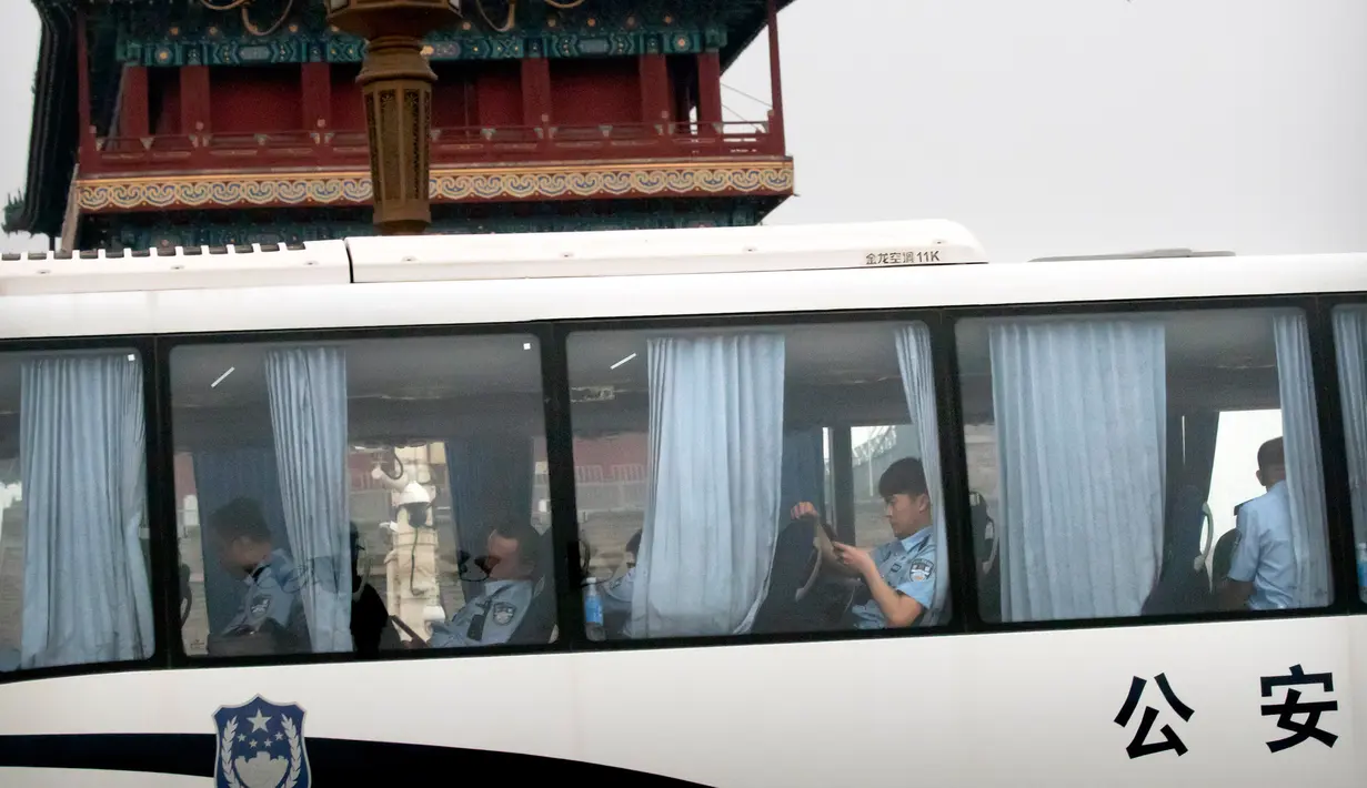 Para petugas keamanan duduk di sebuah bus di Lapangan Tiananmen di Beijing (4/6/2019). Pemerintah China meningkatkan keamanan di sekitar Lapangan Tiananmen di pusat Beijing jelang peringatan tragedi Tiananmen 1989. (AP Photo/Mark Schiefelbein)