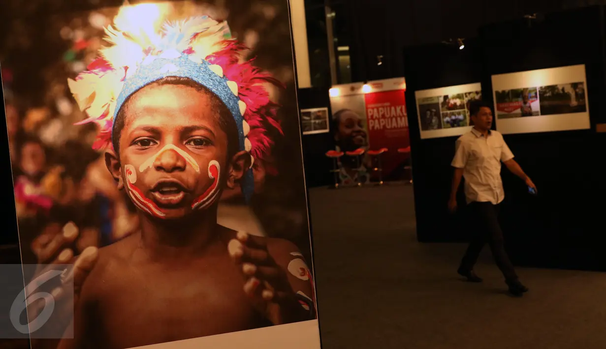 Pengunjung melintas di sekitar lokasi pameran karya foto Papuaku Papuamu di Kuningan City, Jakarta, Selasa (27/12). Sebanyak 117 karya para pewarta foto ditamplkan dalam 40 bingkai. (Liputan6.com/Helmi Fithriansyah)