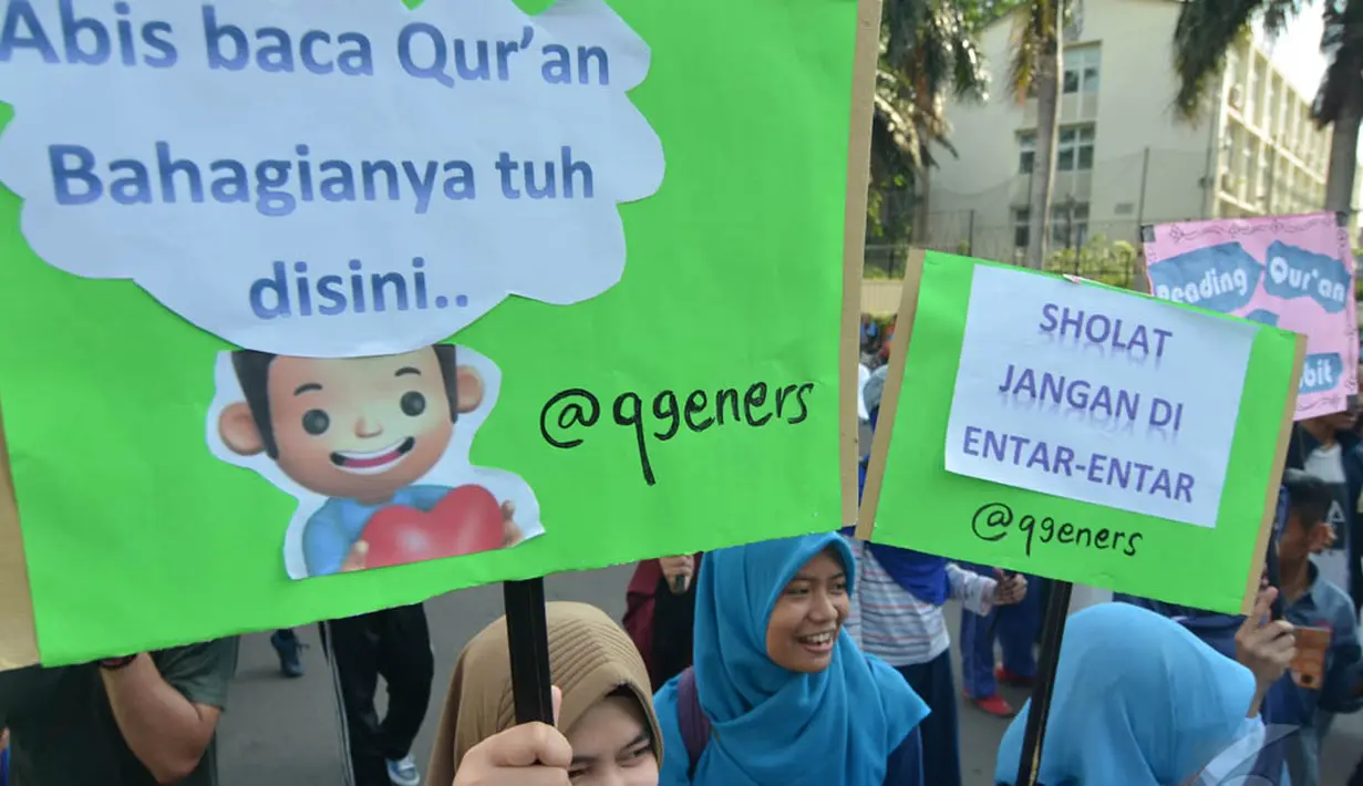 Para aktivis Quran Generation membawa beberapa poster saat aksi di Bundaran HI, Jakarta, Minggu (21/12/2014). (Liputan6.com/Herman Zakharia)