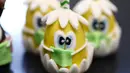 Biskuit berbentuk telur Paskah dengan masker ditampilkan di toko roti Schuerener Backparadies, Dortmund, Jerman, Rabu (8/4/2020). Pembuatan kue Paskah dengan masker bertepatan dengan pandemi virus corona COVID-19. (Ina FASSBENDER/AFP)