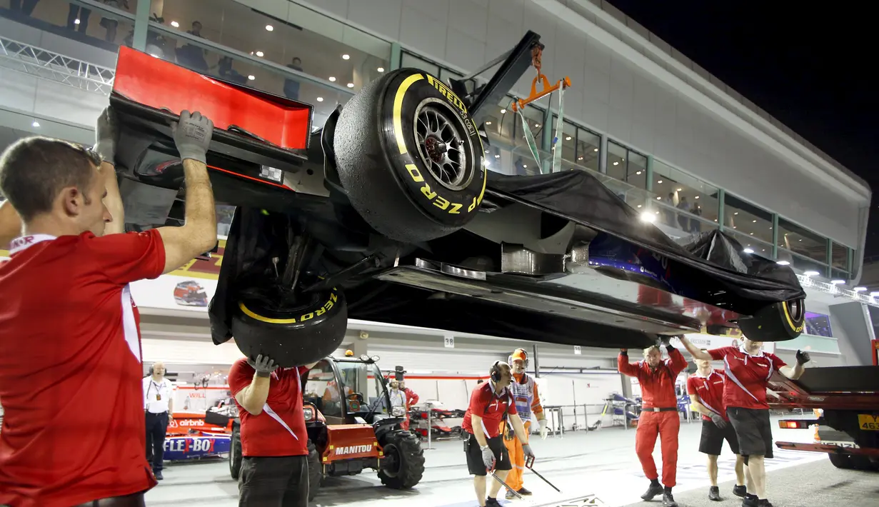 Mekanik Manor Marussia memindahkan mobil rusak Alexander Rossi dari AS ke dalam garasi mereka di Sirkuit Marina Bay saat sesi latihan Grand Prix Singapura F1 (18/9/2015). (REUTERS/Edgar S)
