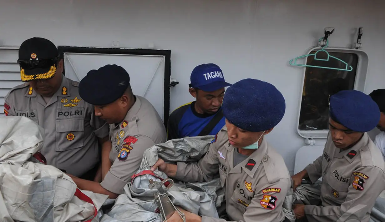 Anggota polisi memindahkan serpihan berupa tangga darurat dan tabung gas yang diduga milik pesawat AirAsia QZ8501 di Pelabuhan Kumai, Pangkalan Bun, Kalteng, Kamis (1/1/2015). (Liputan6.com/Herman Zakharia)