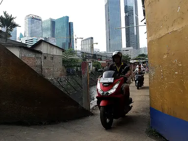 Pengendara sepeda motor melintasi jalur alternatif di belakang Kompleks Patra Jasa, Jakarta Selatan, Rabu (1/3/2023). Jalur alternatif seperti gang, jalan kecil, maupun jalan tembusan menjadi pilihan bagi pengendara sepeda motor untuk menghindari kemacetan di jalan-jalan protokol Ibu Kota. (Liputan6.com/Johan Tallo)
